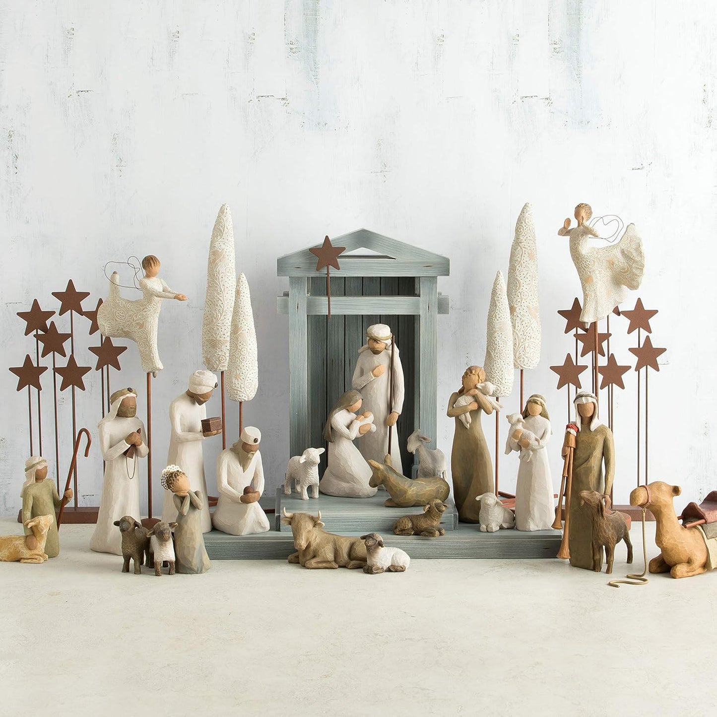 Nativity scene figurine set with stable and figures on a light background