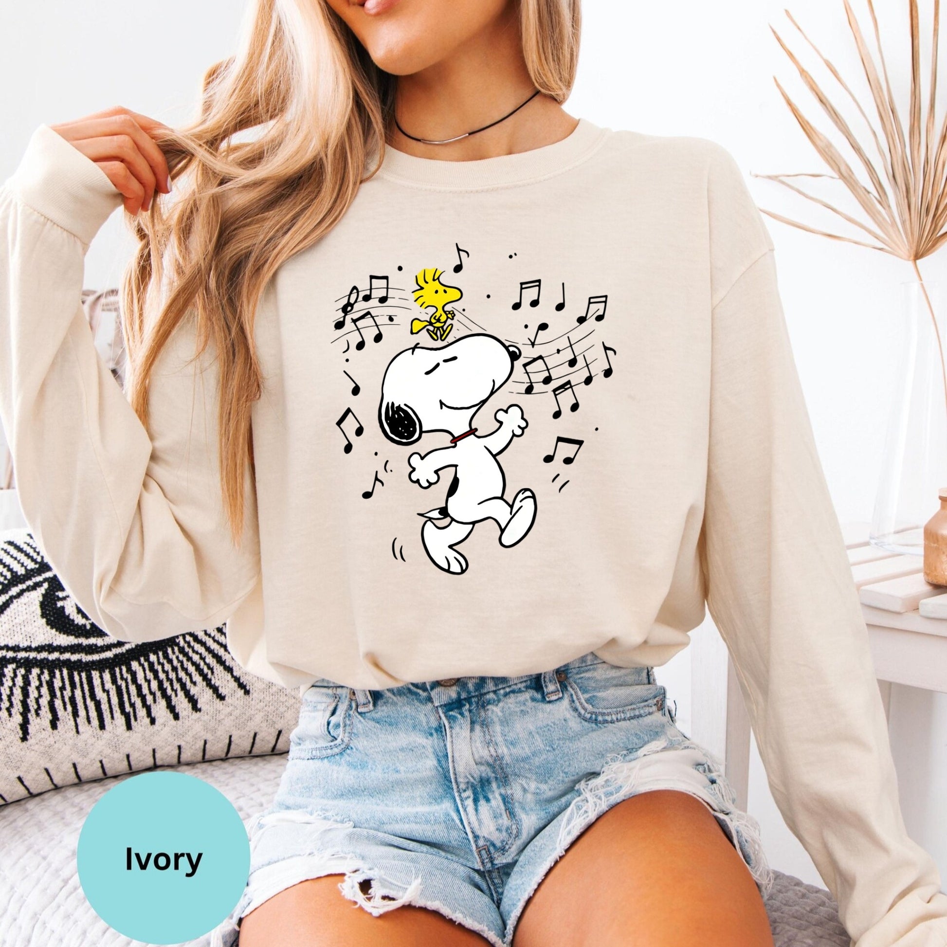Ivory long sleeve woman wearing dancing Snoopy music graphic