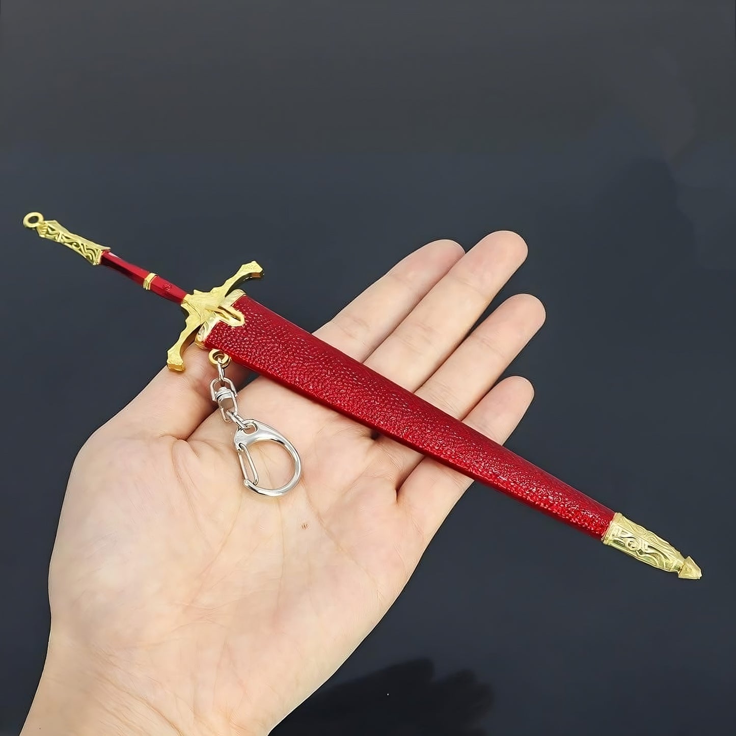 Mini medieval greatsword replica held in hand showing size scale