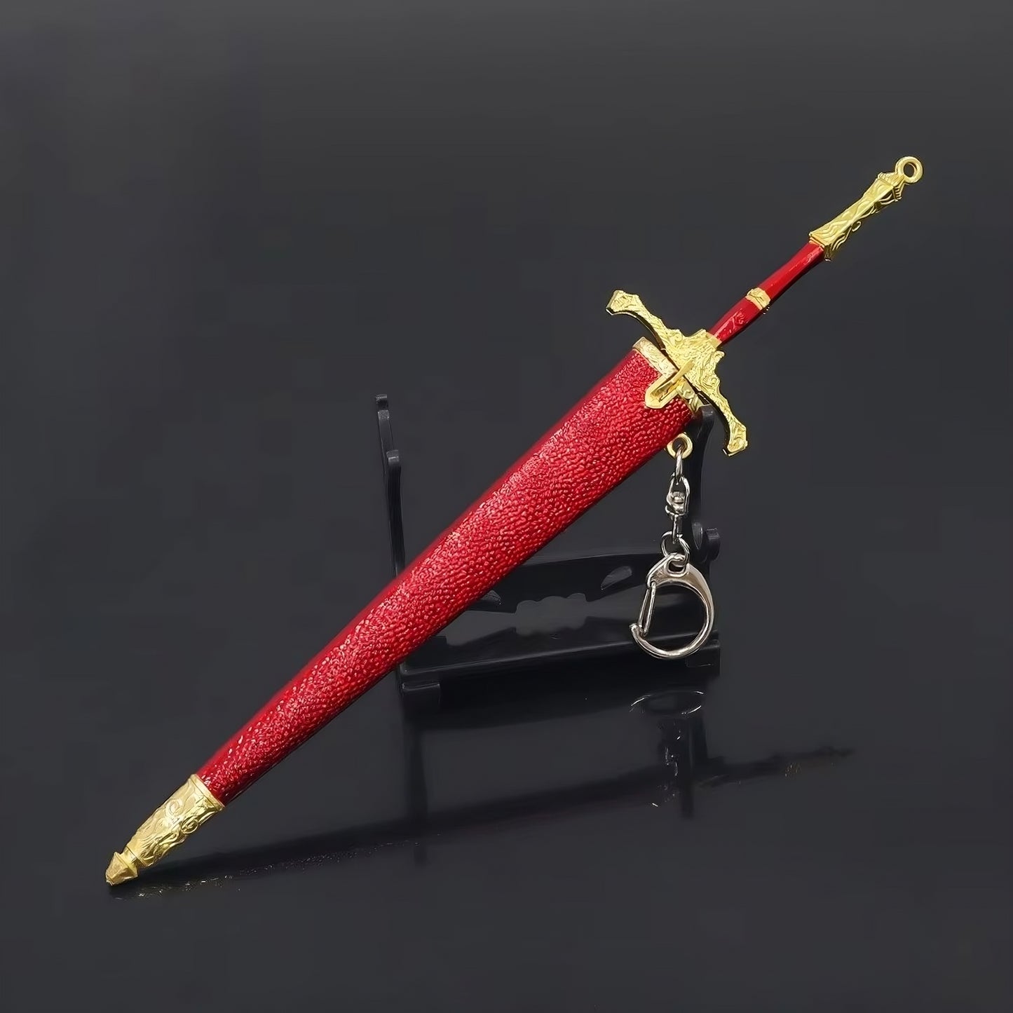 Mini fantasy sword replica displayed vertically on stand with scabbard