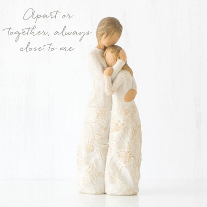 Decorative figurine of two people embracing with text 'Apart or together, always close to me' on a white background