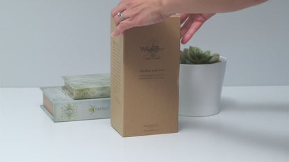 Hands opening a Willow Tree figurine box to reveal the hand-painted sculpture inside