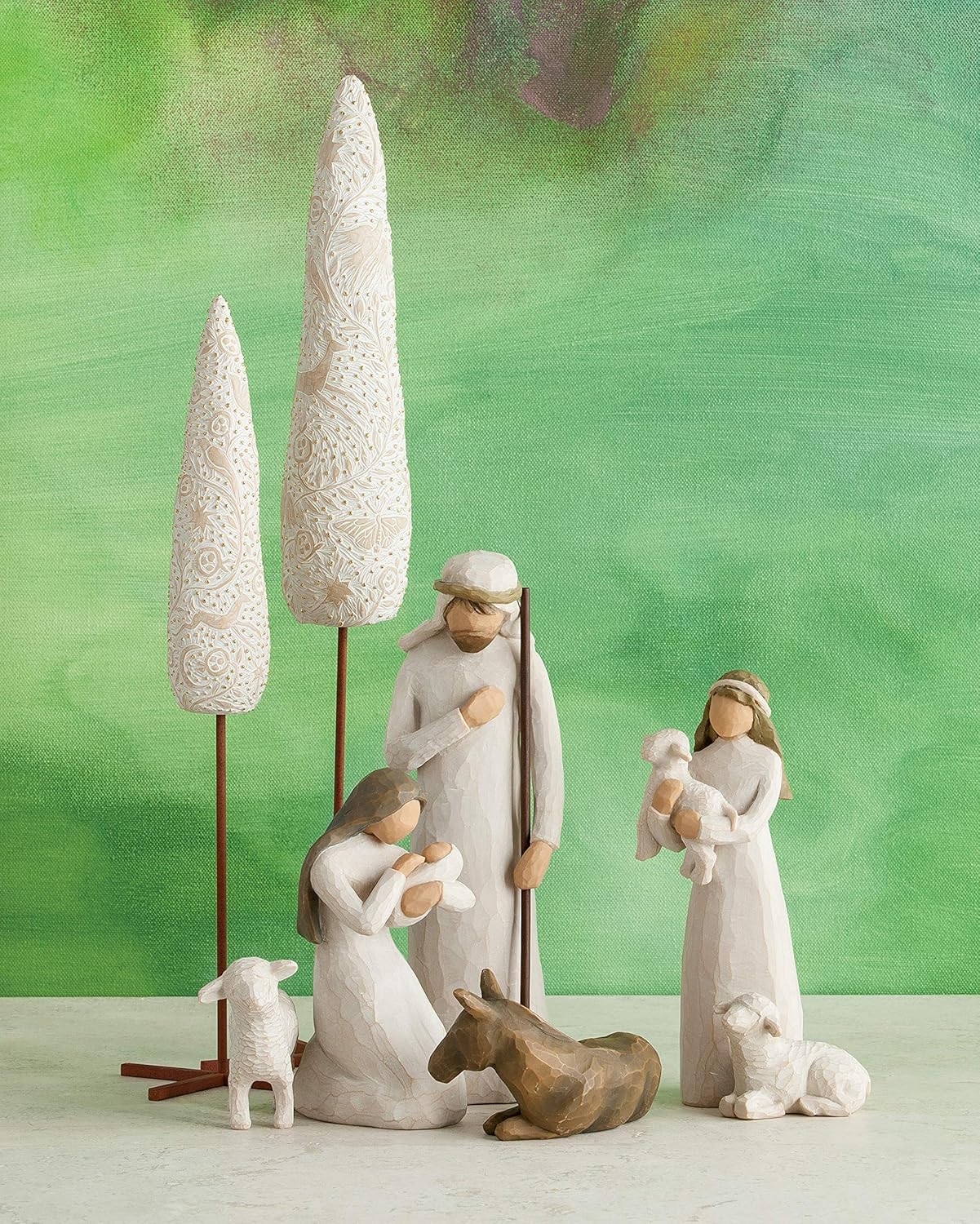 Nativity scene with three figures against a green background