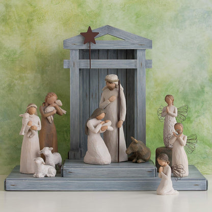 Nativity scene figurine set with stable and figures on a green background