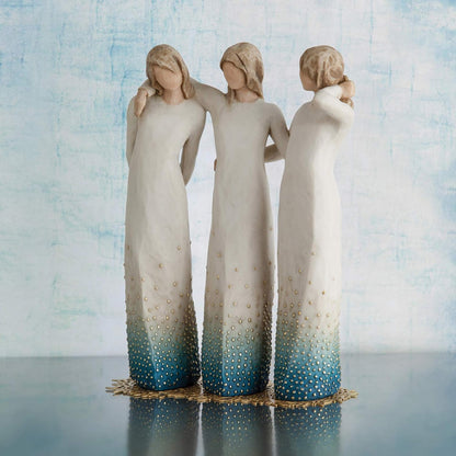 Three angel figurines with gradient blue and white dresses against a light blue background