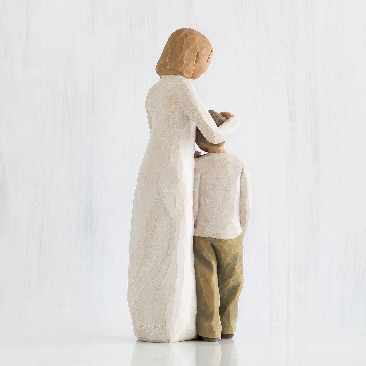 Statue of a mother and child embracing on a white background