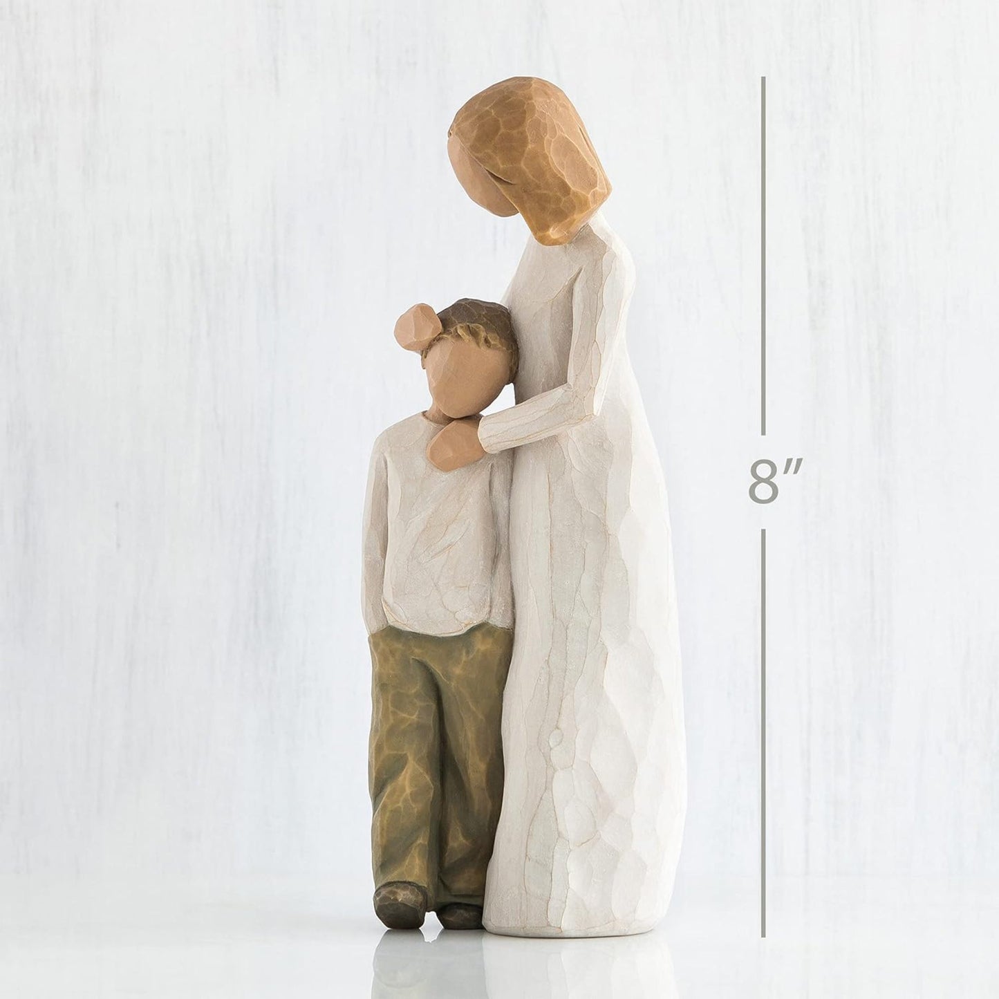 Decorative figurine of a woman and child embracing on a white background with a measurement label.