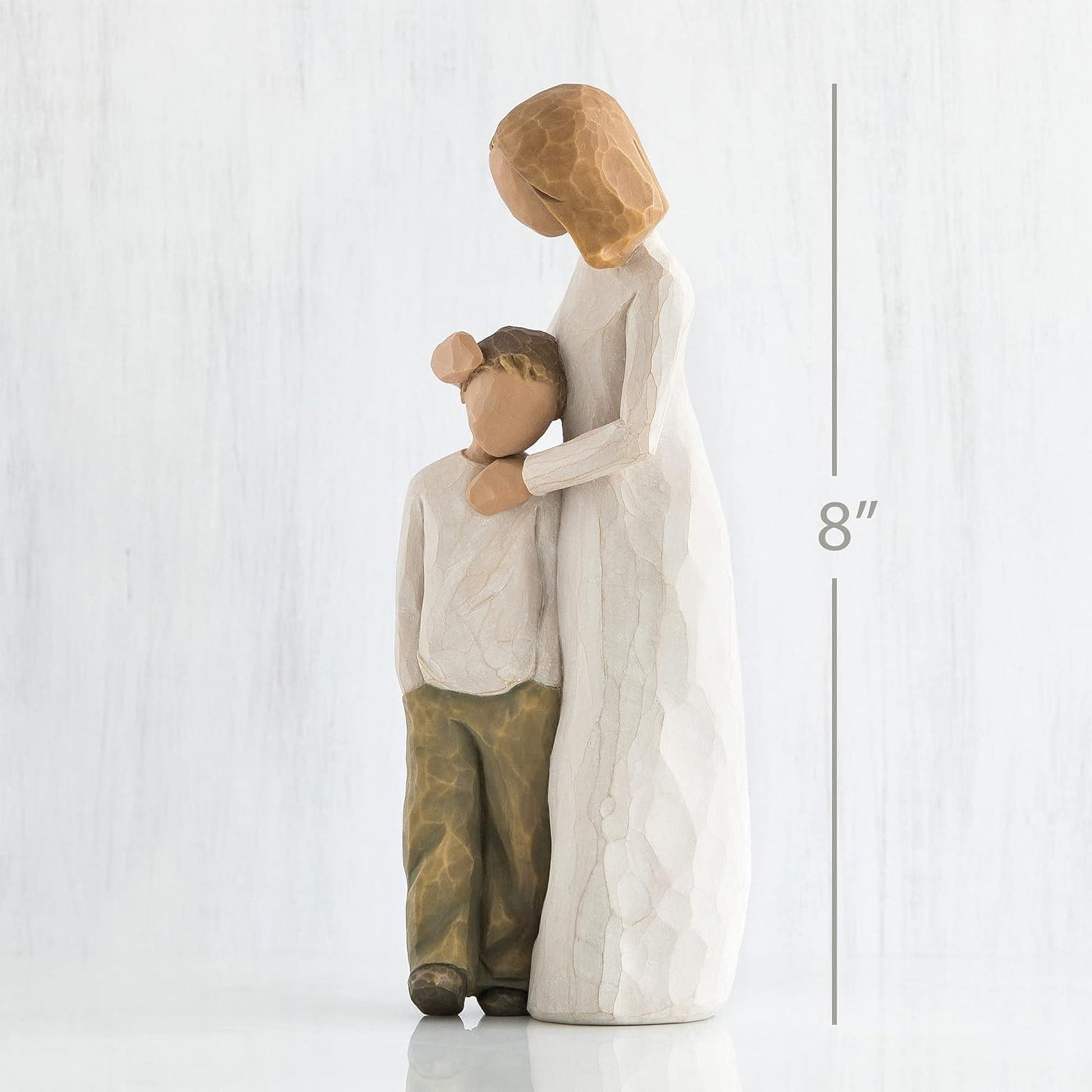 Decorative figurine of a woman and child embracing on a white background with a measurement label.