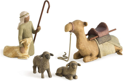 Set of nativity scene figurines including a shepherd, two sheep, and a camel on a white background.