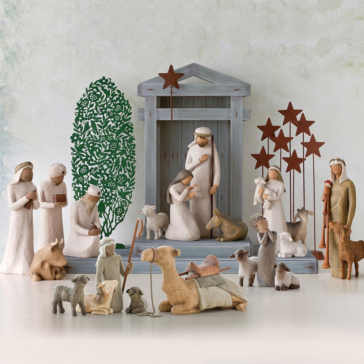 Willow Tree nativity scene with shepherd, Holy Family, camels, sheep, and stable animals, hand-painted resin figurines arranged around a classic manger
