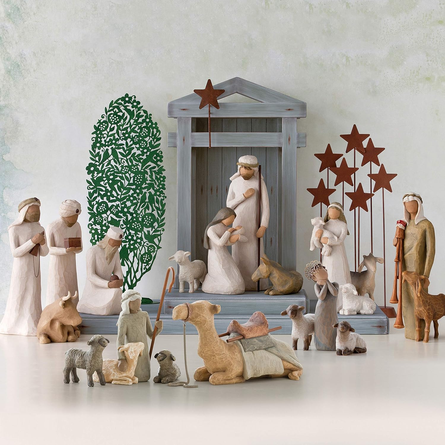 Willow Tree nativity scene with shepherd, Holy Family, camels, sheep, and stable animals, hand-painted resin figurines arranged around a classic manger
