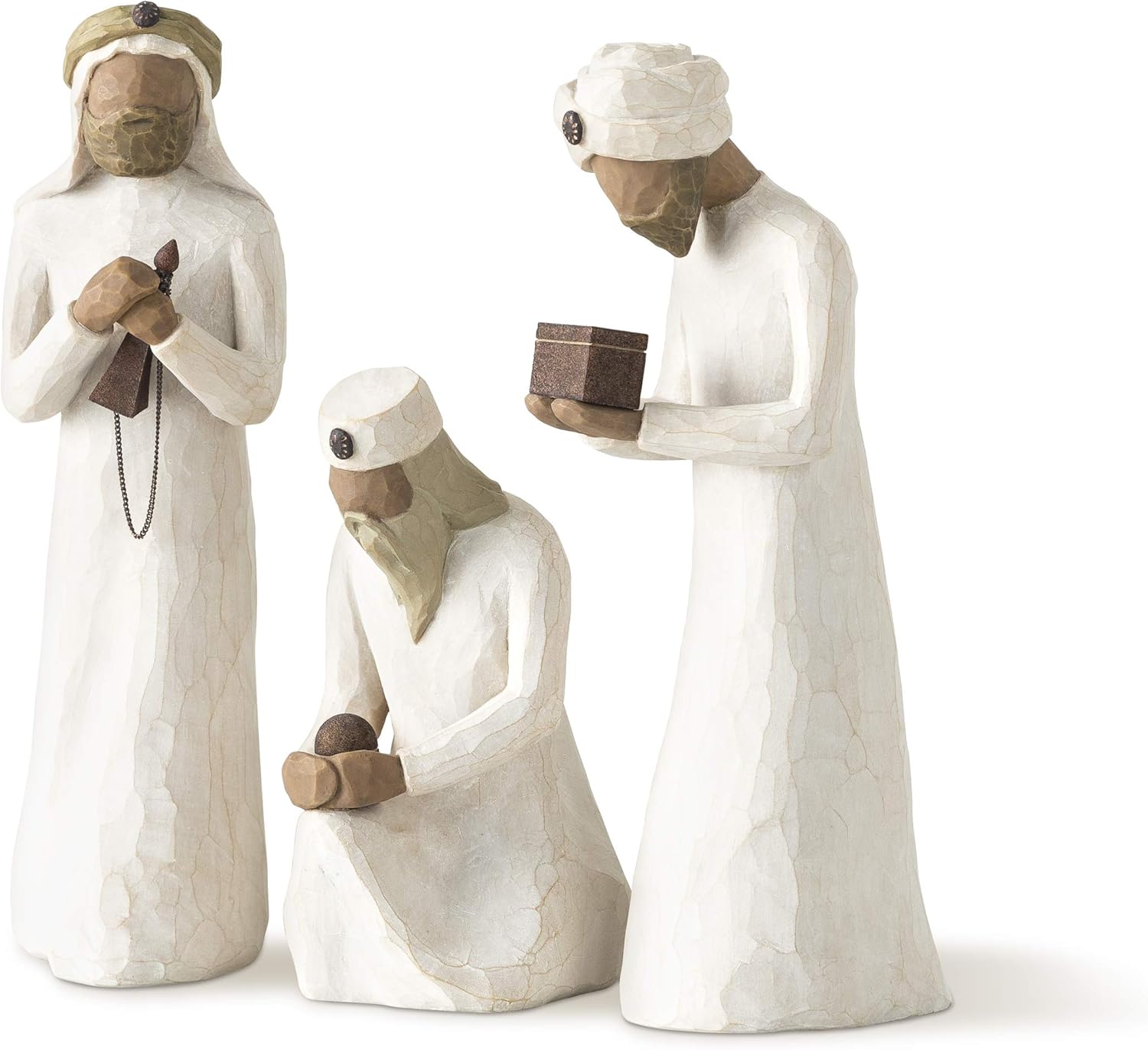 Three white figurines with headscarves and robes on a white background