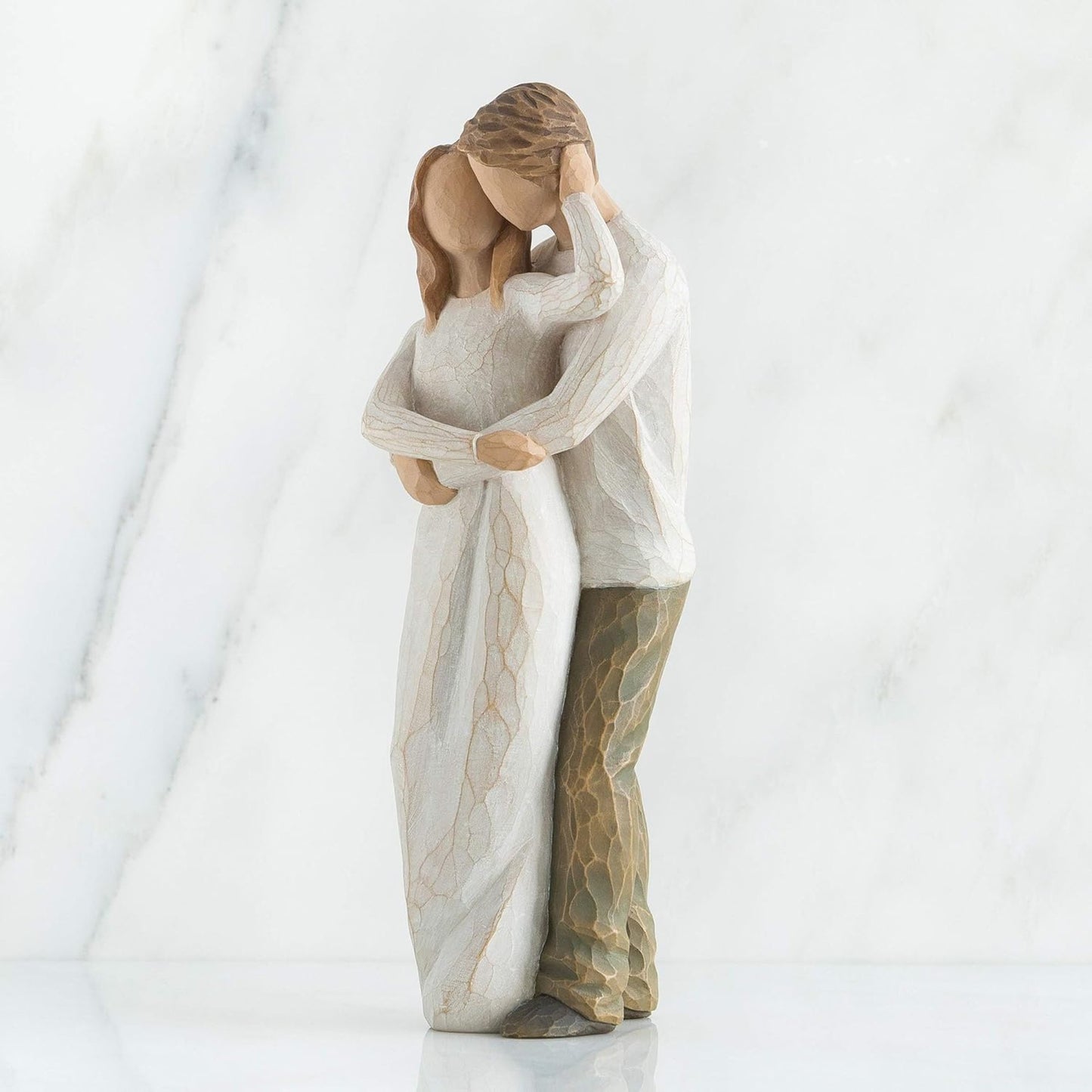 Statue of two people embracing on a white background