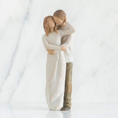 Statue of a couple embracing wrapped in a blanket on a white background